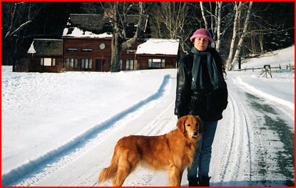 Gail and Wilbur pose on a snowy driveway in front of their home